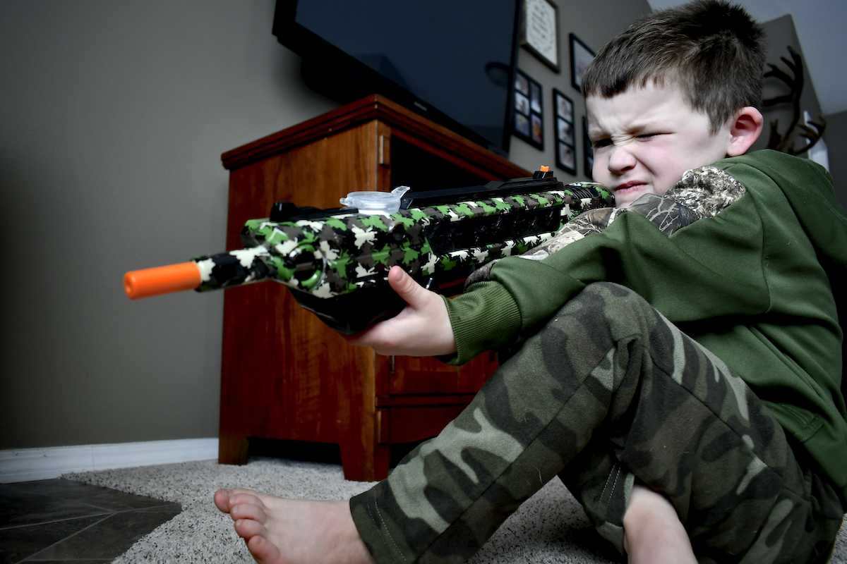 small child takes aim with bug a salt toy