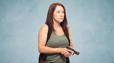 Woman holds impressive pistol, more impressive resting face.