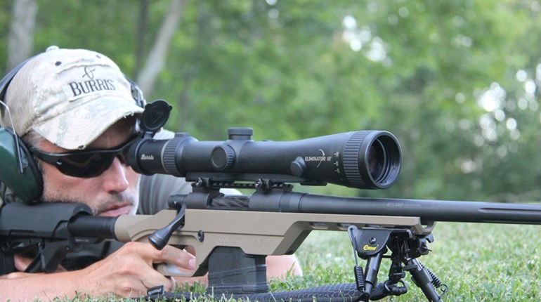 author taking aim with scoped bolt-action precision rifle