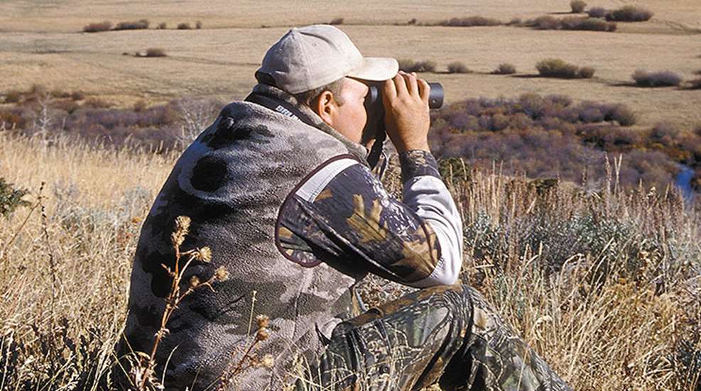 man looking through binocular