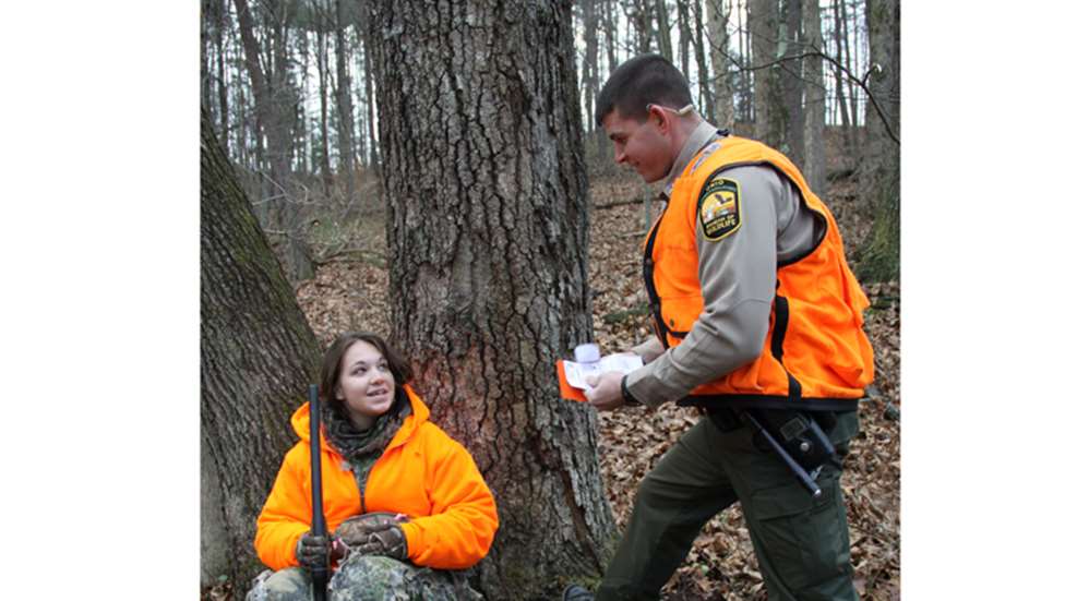 wildlife officer checks woman's hunting license