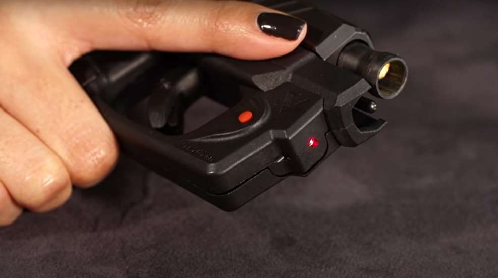 close detail shot of woman's hand holding Taurus G series pistol with Viridian laser mounted