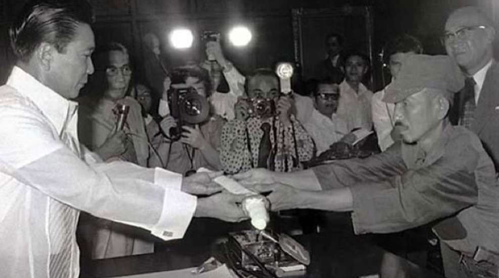 Onoda surrenders his sword to his former commander