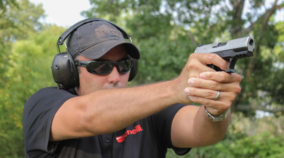 author demonstrates isosceles stance with semi-auto handgun