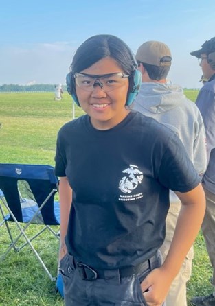 Lucy Kores wearing eye and ear protection, smiling