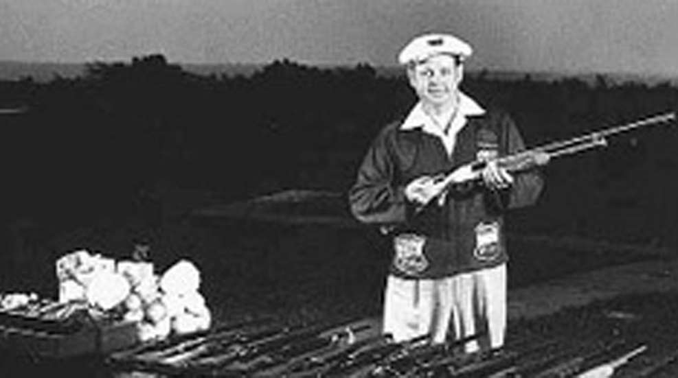 Herb Parsons standing while holding shotgun