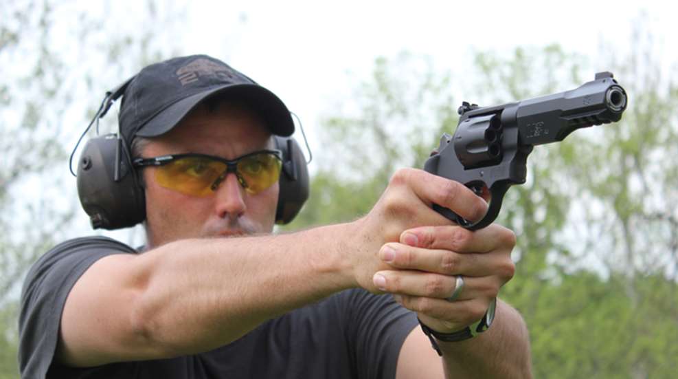 Author wearing eye and ear protection shooting big-bore revolver